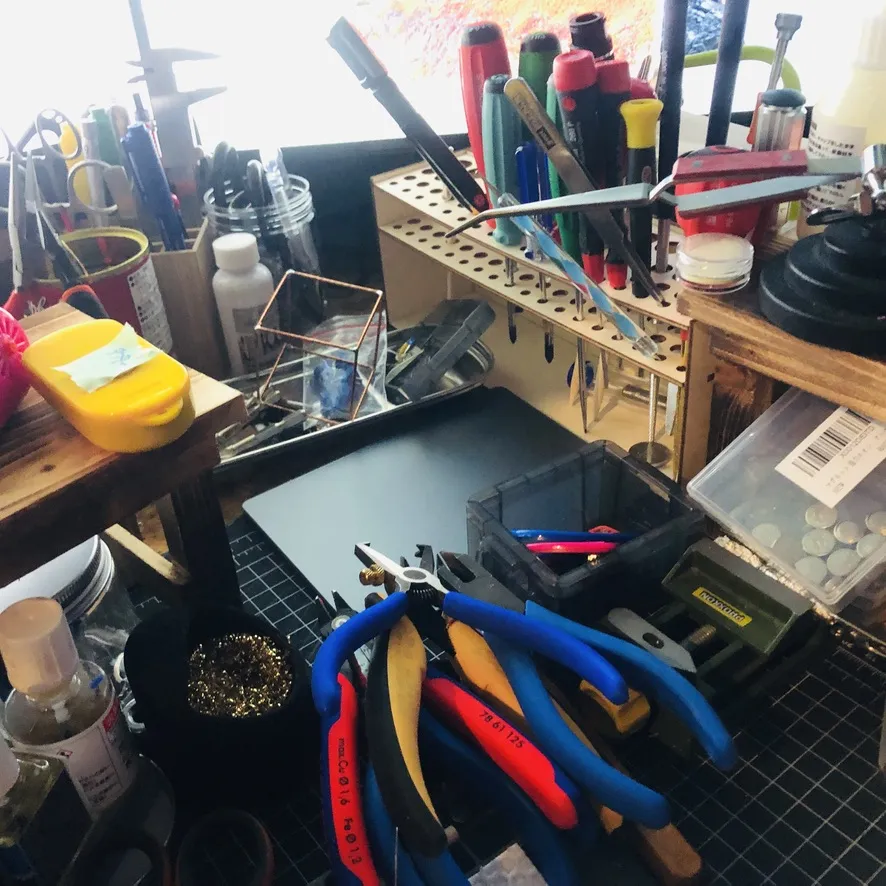 ペンチや工具が並ぶ作業台と、黄色い本体