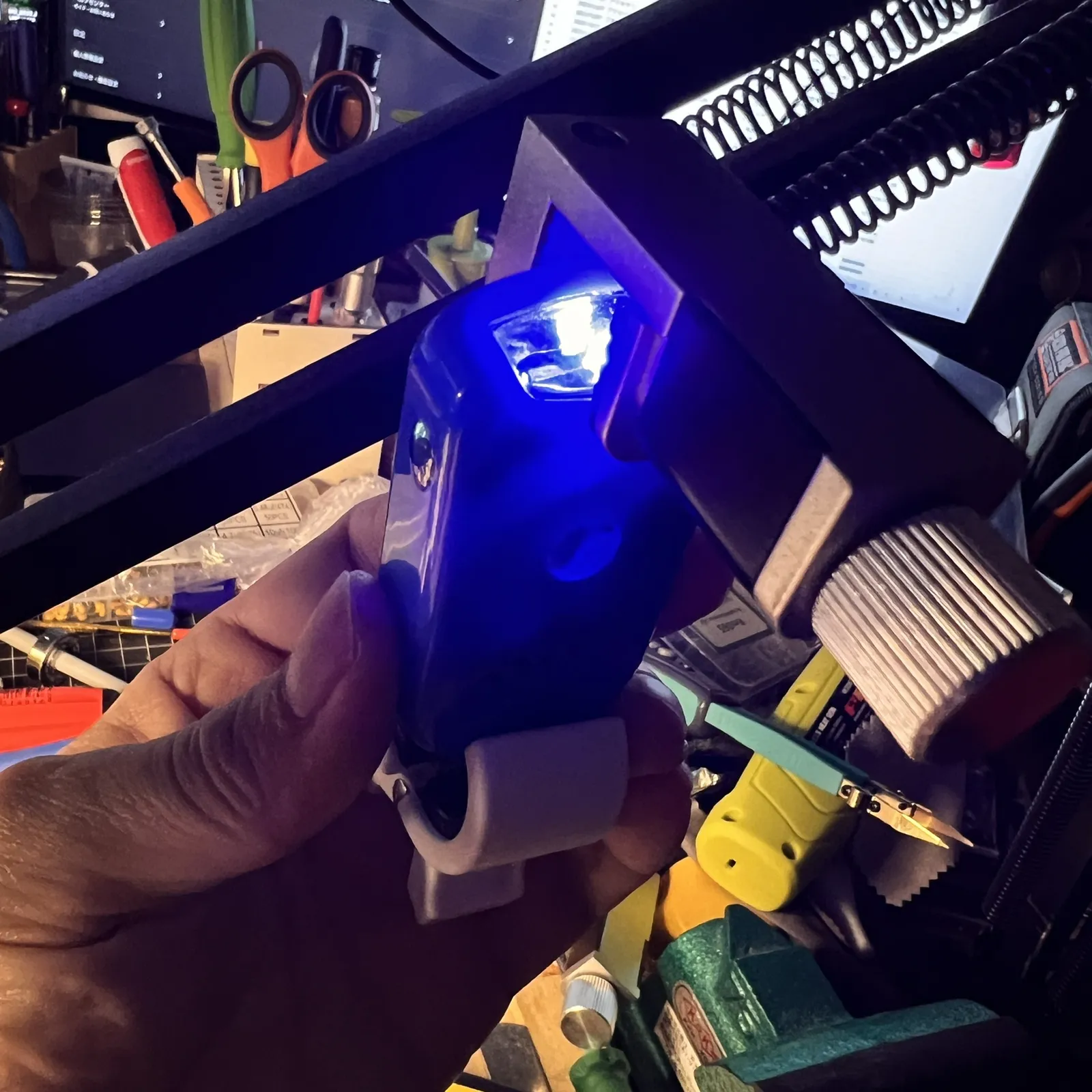青いLEDが光る本体を、作業中に手で持っている