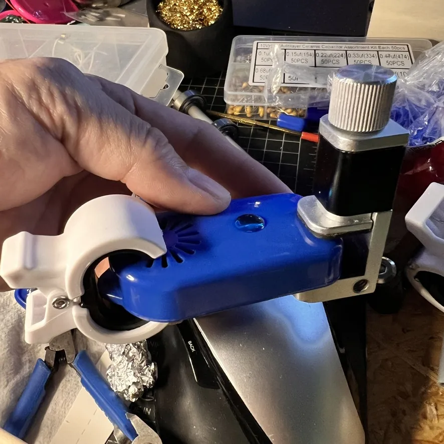 青い本体を持つ手。白いクリップに付けて作業している
