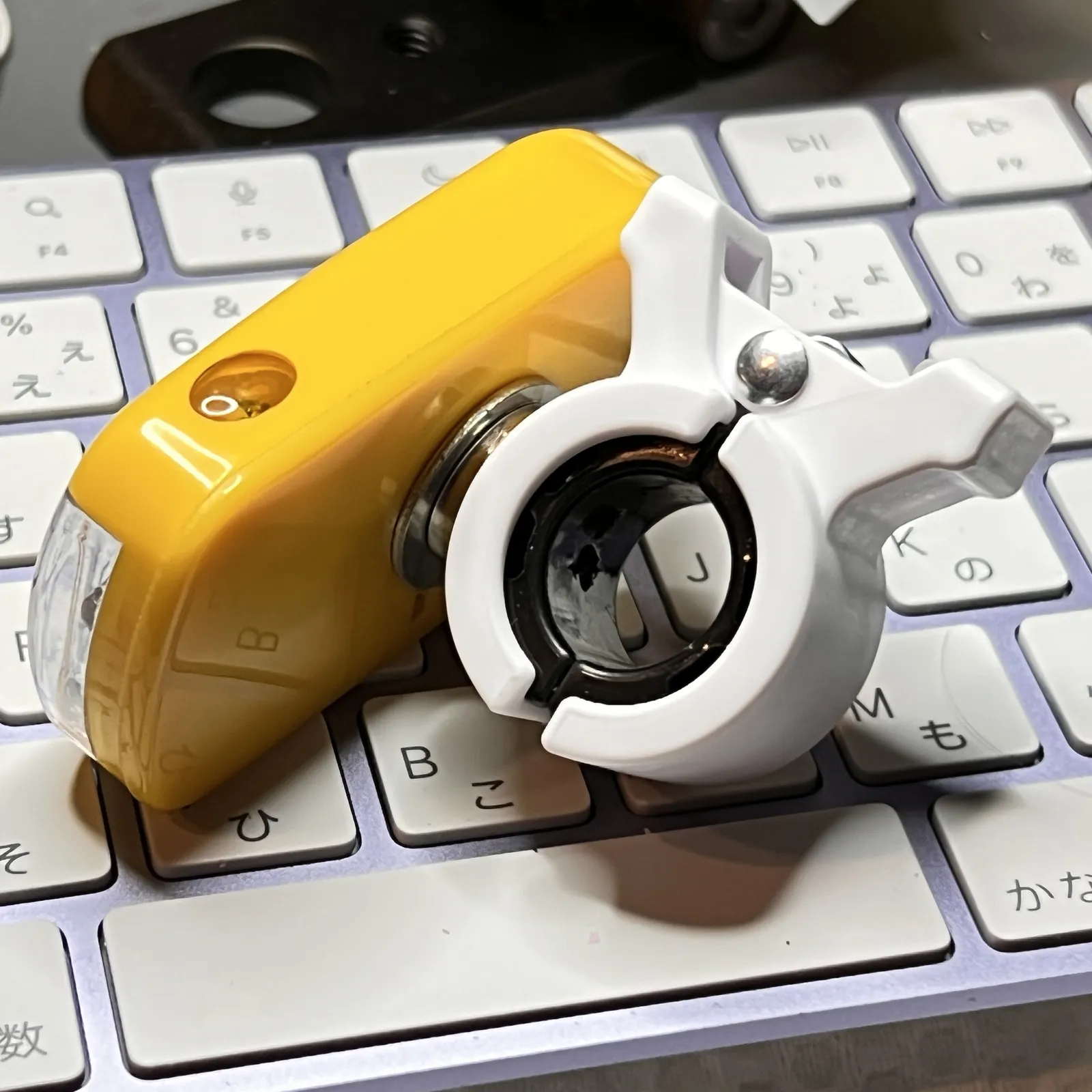 キーボードの上で、黄色い本体を白いクリップに付けたところ