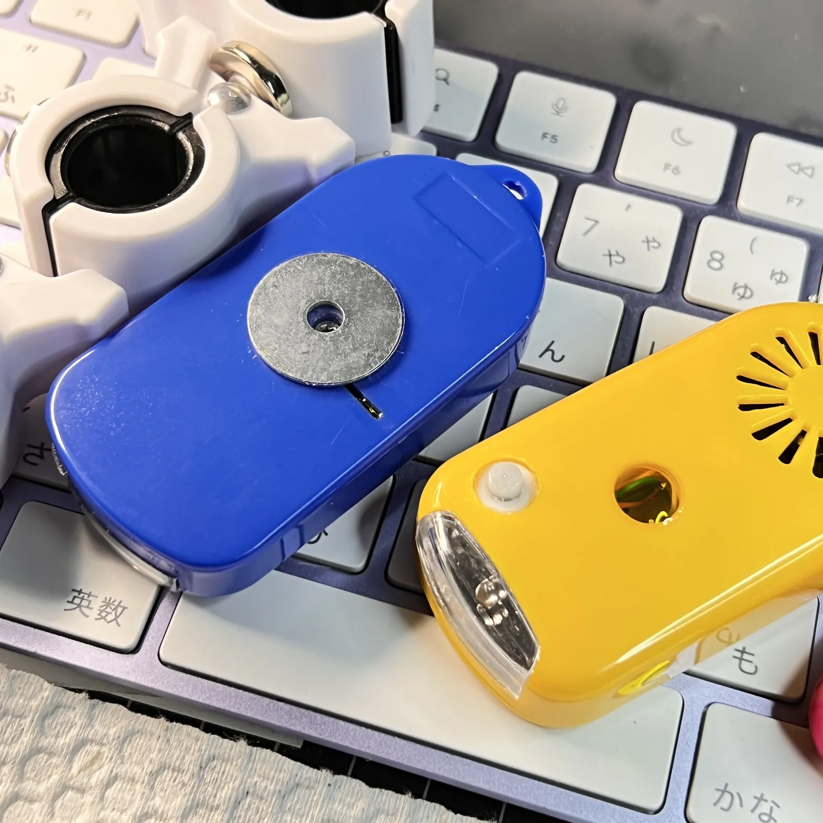 青い本体の裏の金属板と、黄色い本体と白いクリップ