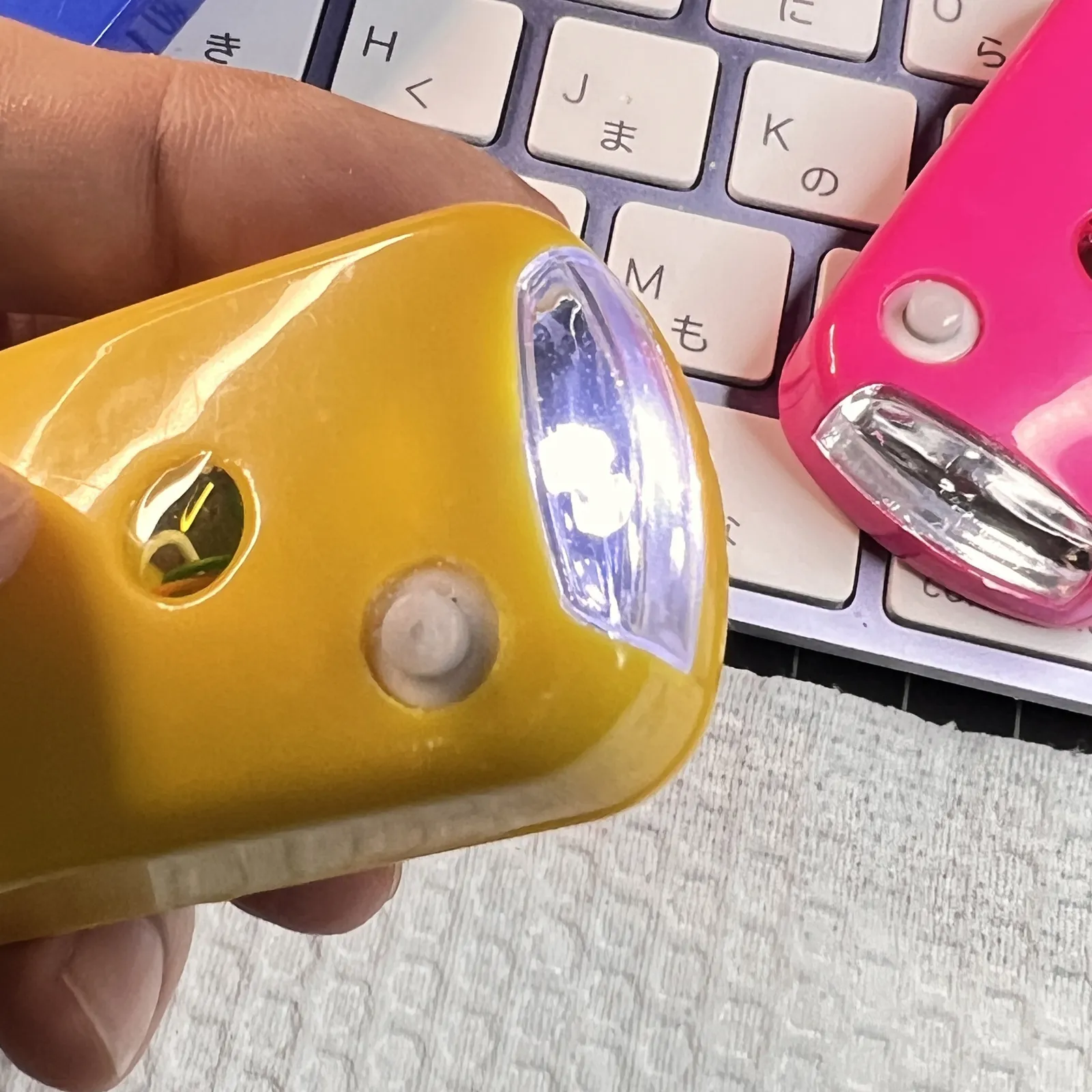 手に持った黄色い本体。前のLEDが光っている